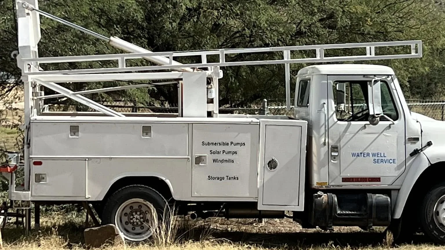 The company's water well service truck, lettered for submersible pumps, solar pumps, windmills and storage tanks
