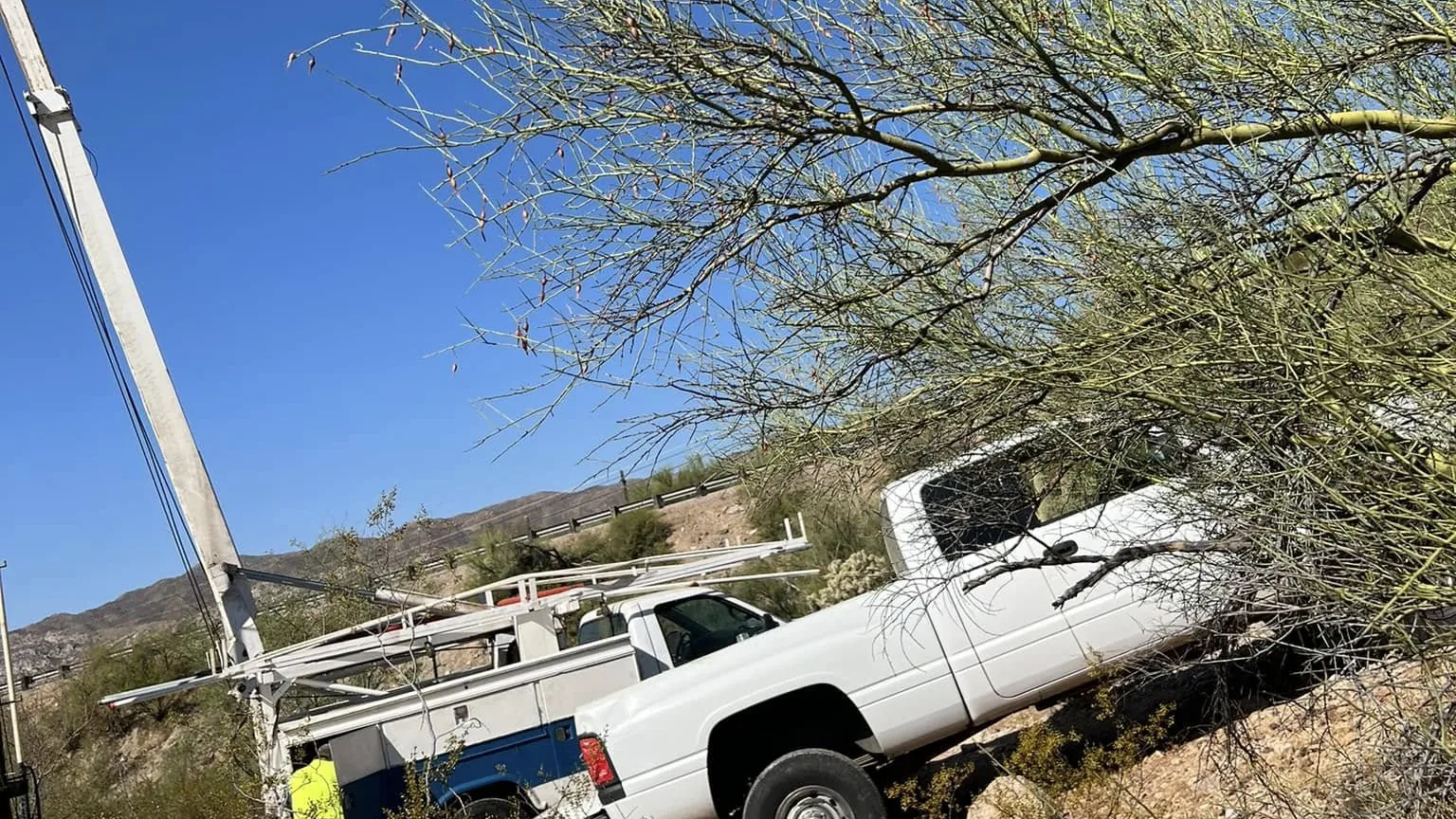 Pump hoist rig reaching down to a well on a steep desert slope